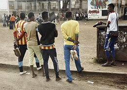 5 soccer players behind the scens of a film set in the neighborhood California, an urban area in Nairobi, Kenya. Boys holding shoes